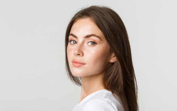 Portrait of confident beautiful brunette woman turning face at camera with dreamy look, white background